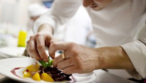 Chef in restaurant kitchen cooking, only hands to be se