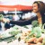 Young woman buying vegetables at farmers market